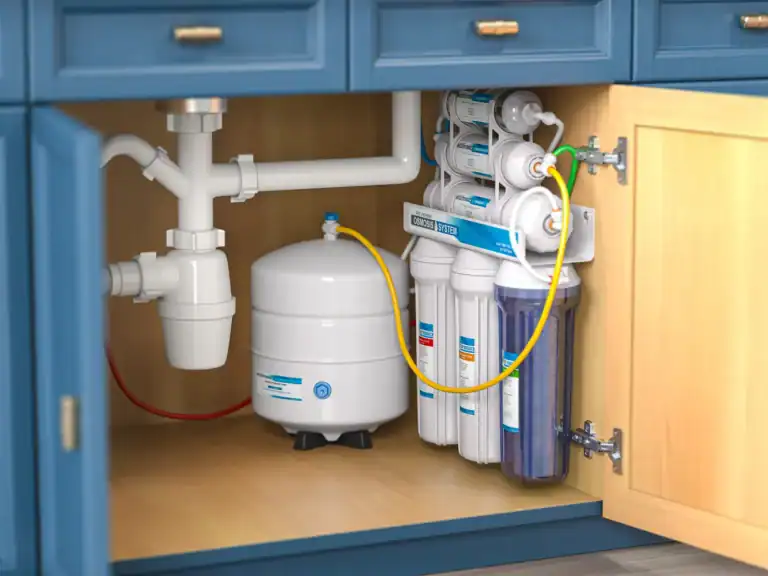 An under-sink water filtration system and its white pressure tank are neatly installed inside a blue kitchen cabinet, showcasing a complete home water purification system in Lake County, FL.
