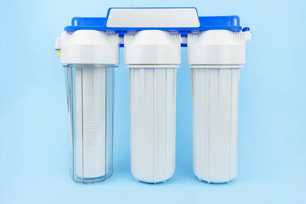 Three-stage water filtration system with white cartridges and blue bracket, used in homes in Lake County, FL.